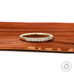 Close up of 1.5mm round brilliant lab diamonds in yellow gold band