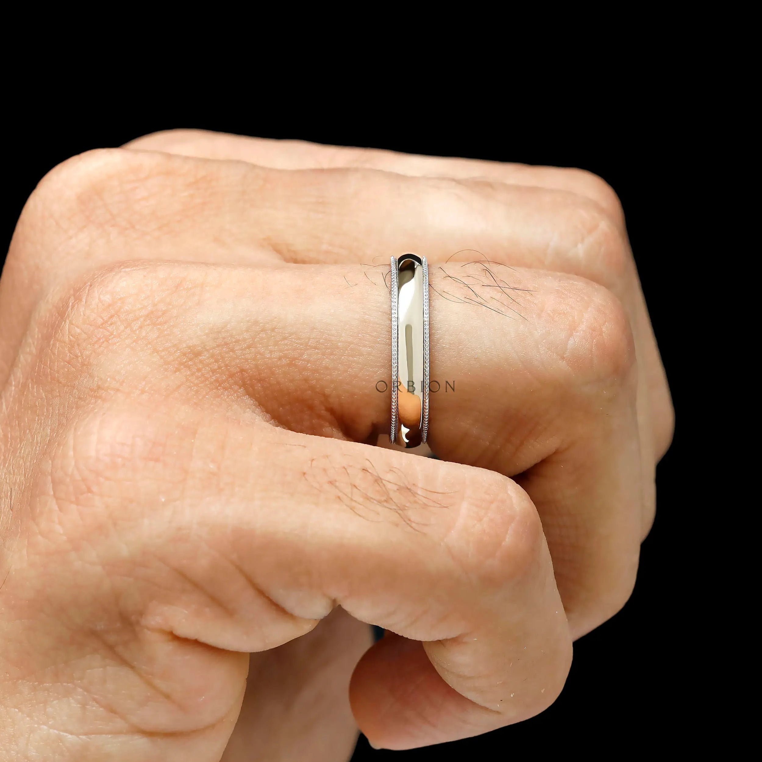 Hand wearing mens milgrain wedding band two tone gold