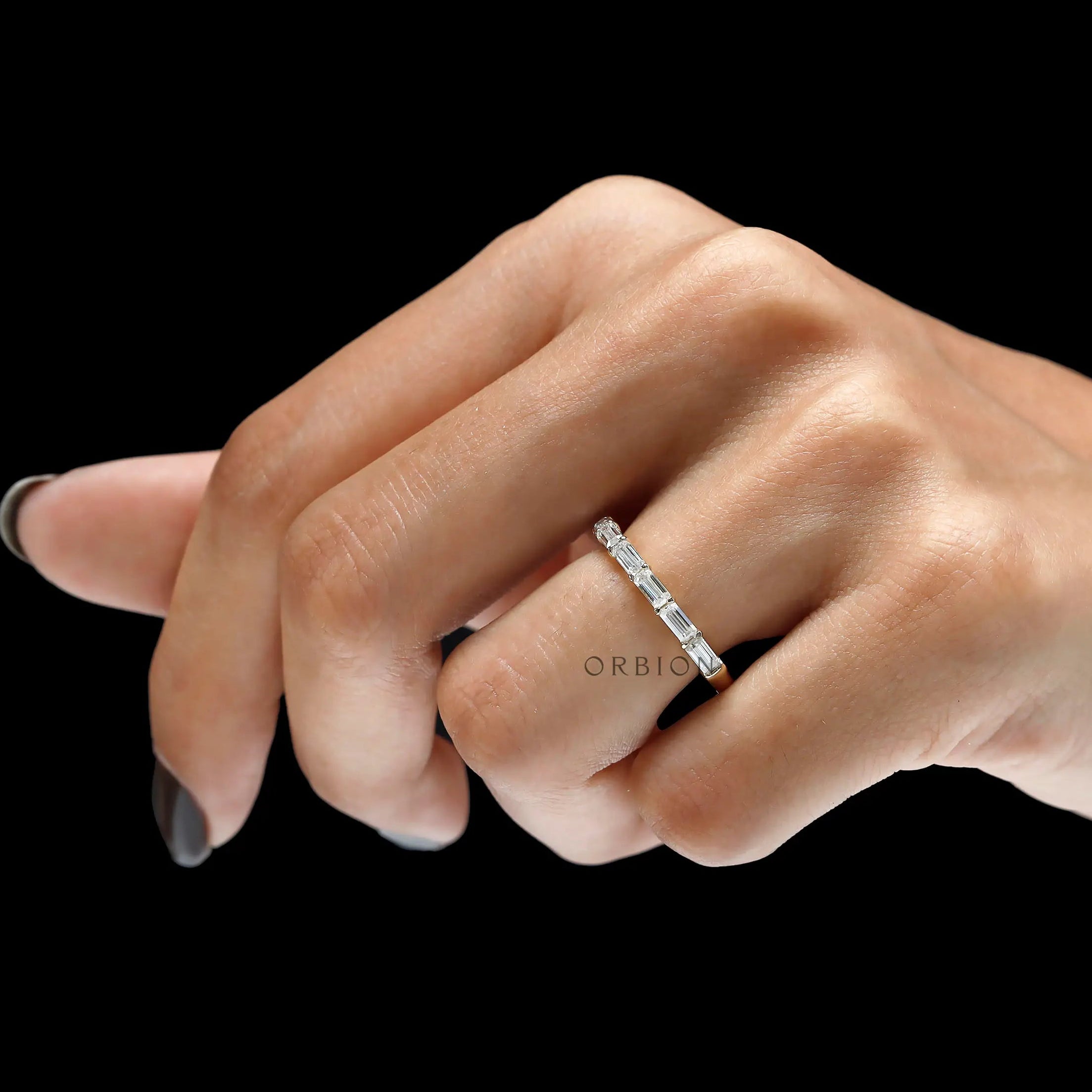 Emerald cut east west lab diamond band ring on wood surface