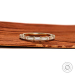 Close up emerald step cut half eternity band ring yellow gold