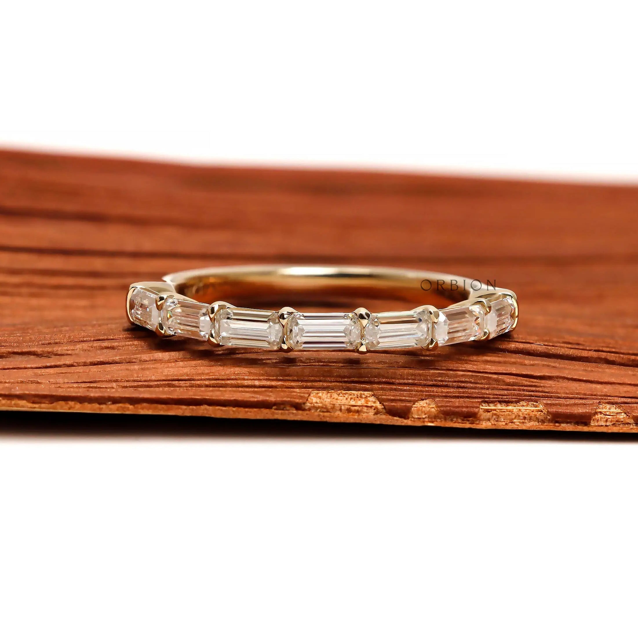 Close up emerald step cut half eternity band ring yellow gold