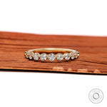 Front view of round lab diamond shared prong half eternity wedding band