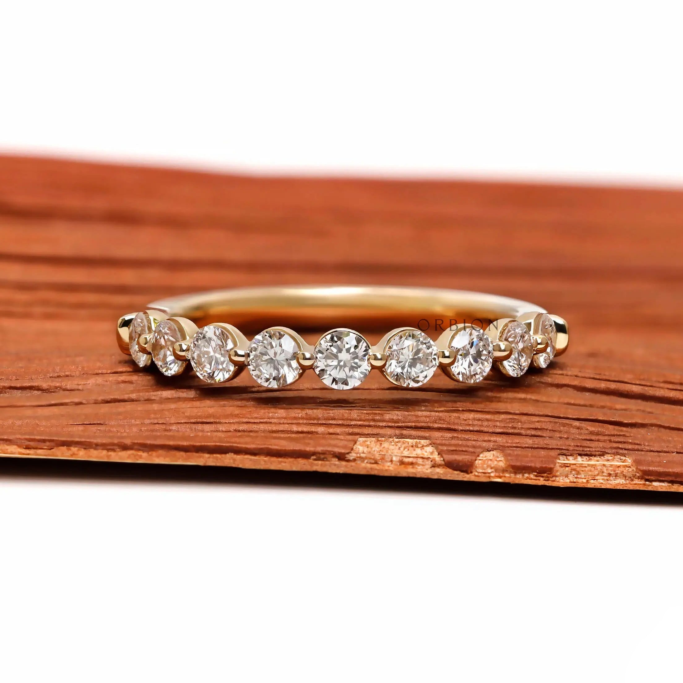 Front view of round lab diamond shared prong half eternity wedding band