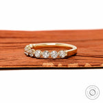 Angled front view of round lab diamond shared prong half eternity wedding band