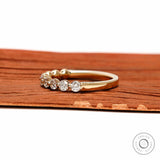 Side profile view of round lab diamond shared prong half eternity wedding band