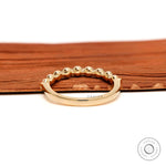 Back view of round lab diamond shared prong half eternity wedding band