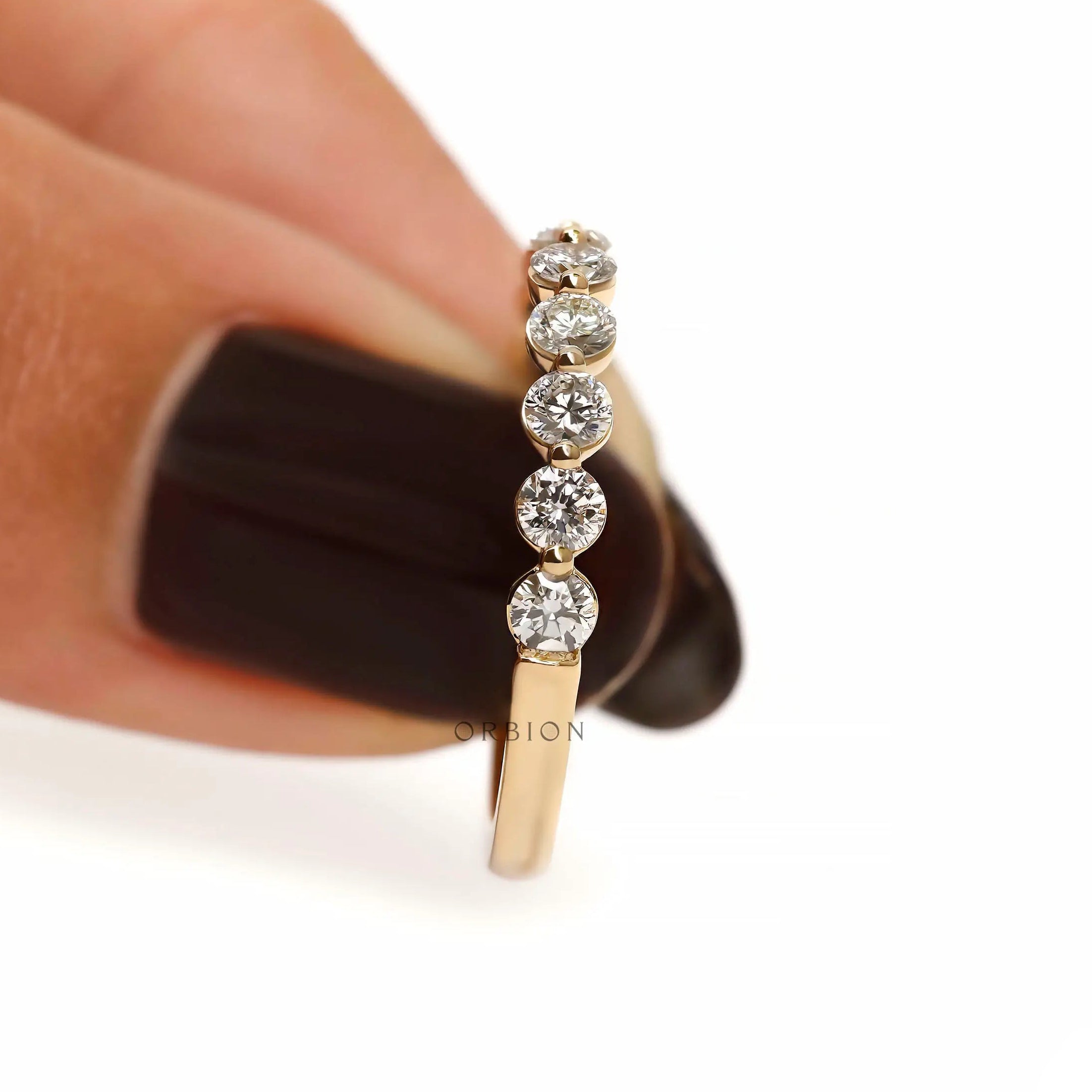 Vertical side detail view of round lab diamond shared prong half eternity band