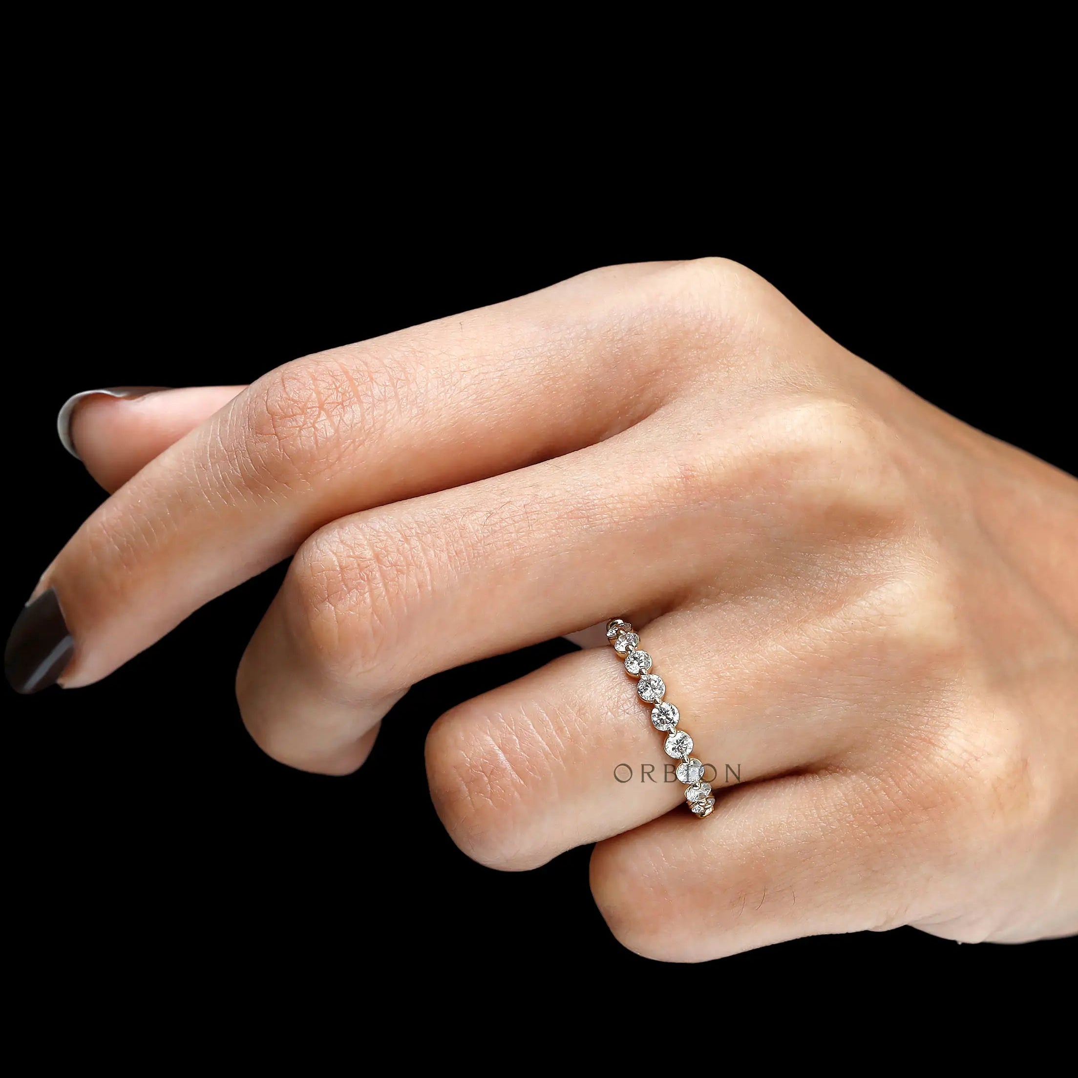 Top hand view of round lab diamond shared prong half eternity band