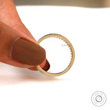 Minimalist baguette moissanite band held between fingers