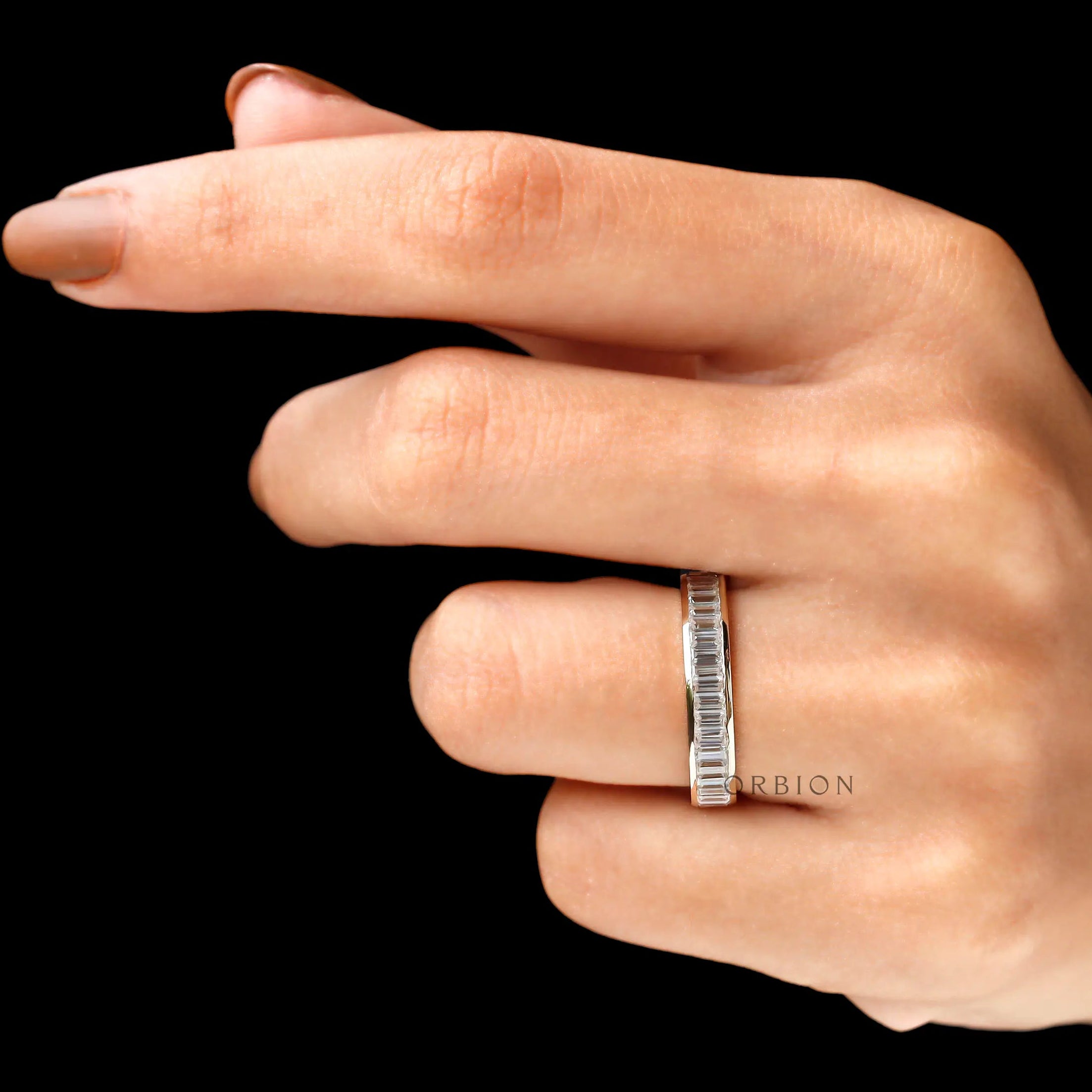 Close-up of baguette moissanite stones in channel worn on hand