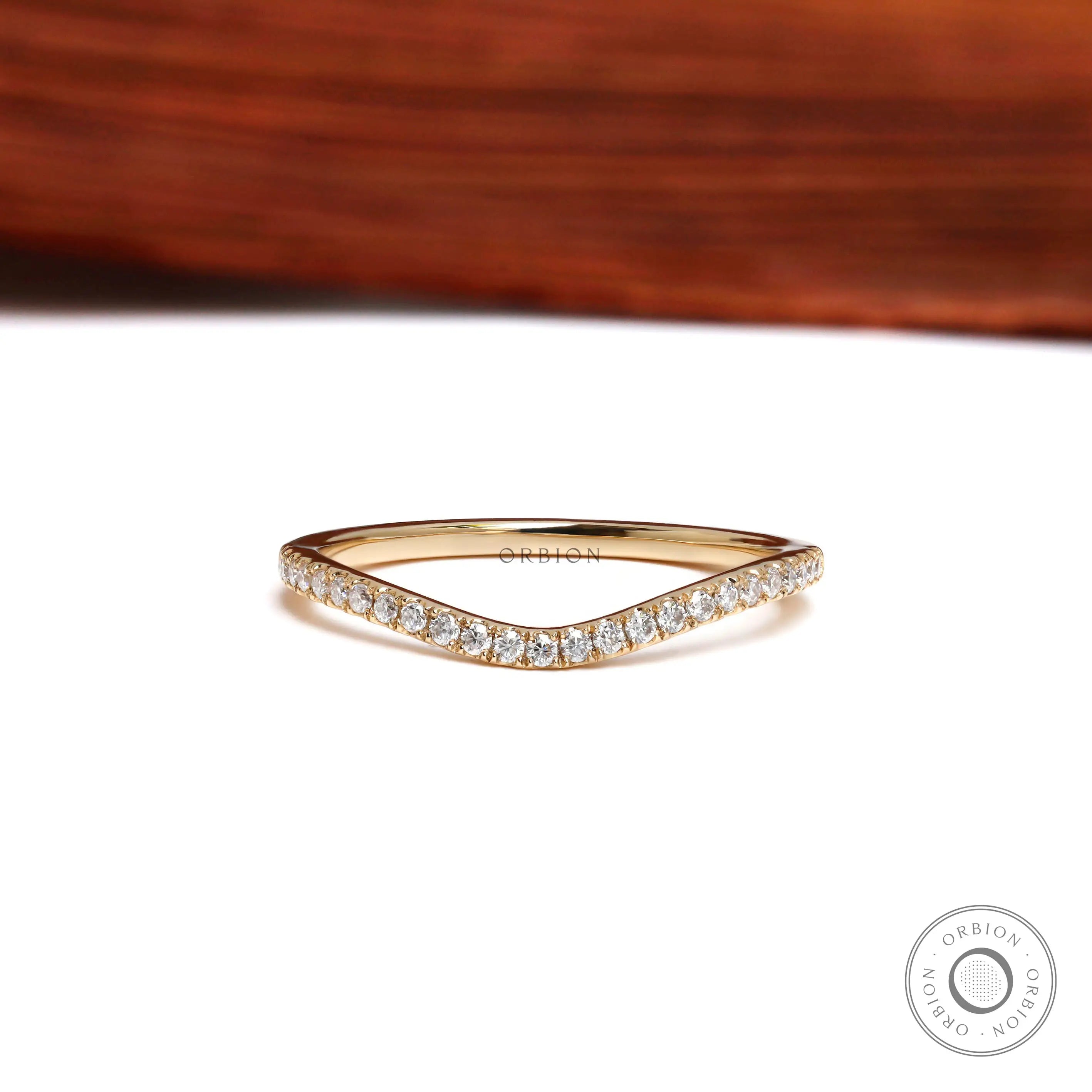 Front view of curved half eternity moissanite wedding band in yellow gold