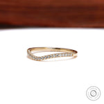Front angled view of curved moissanite wedding band in yellow gold