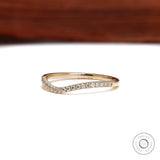 Front angled view of curved moissanite wedding band in yellow gold