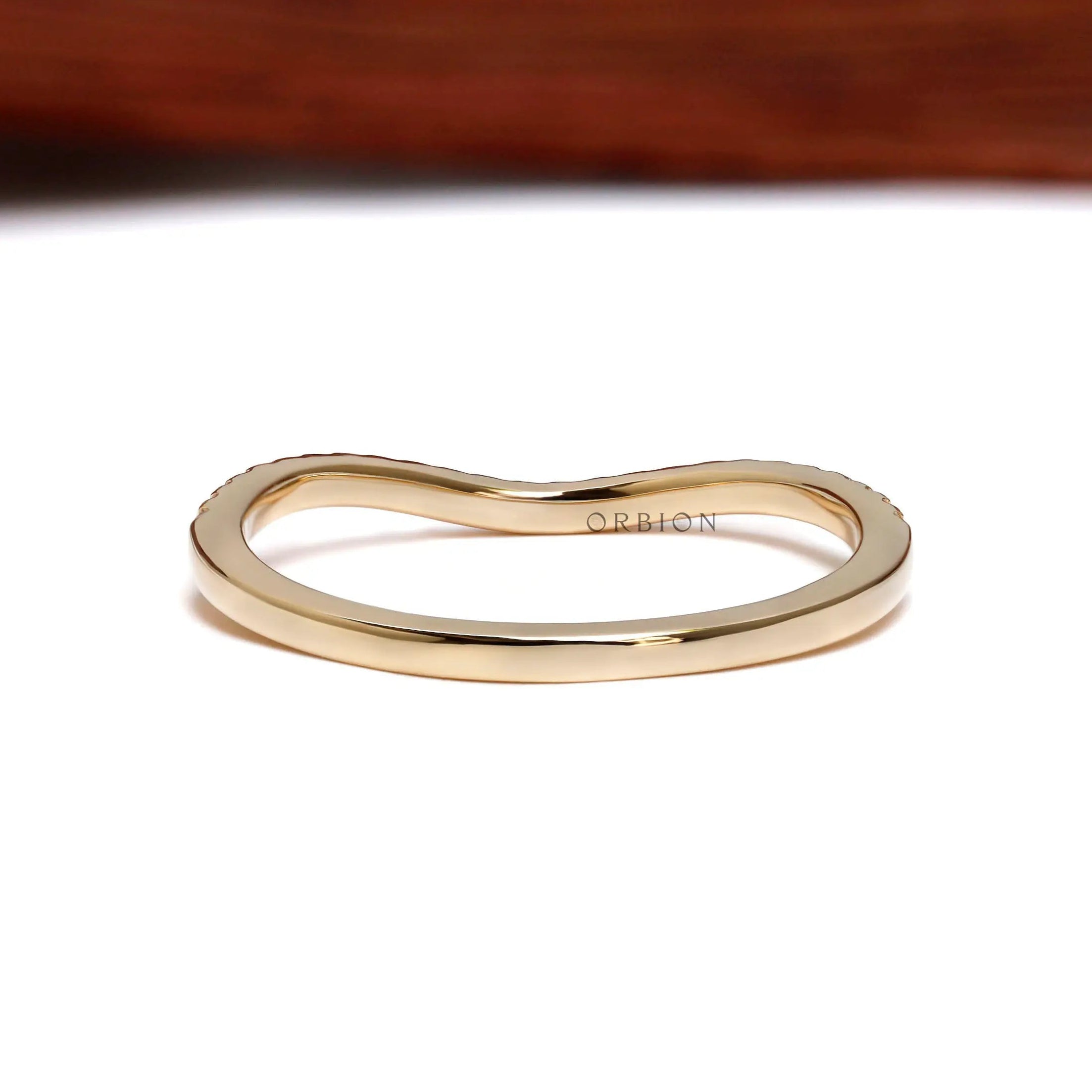 Back view of unique curved wedding band in yellow gold