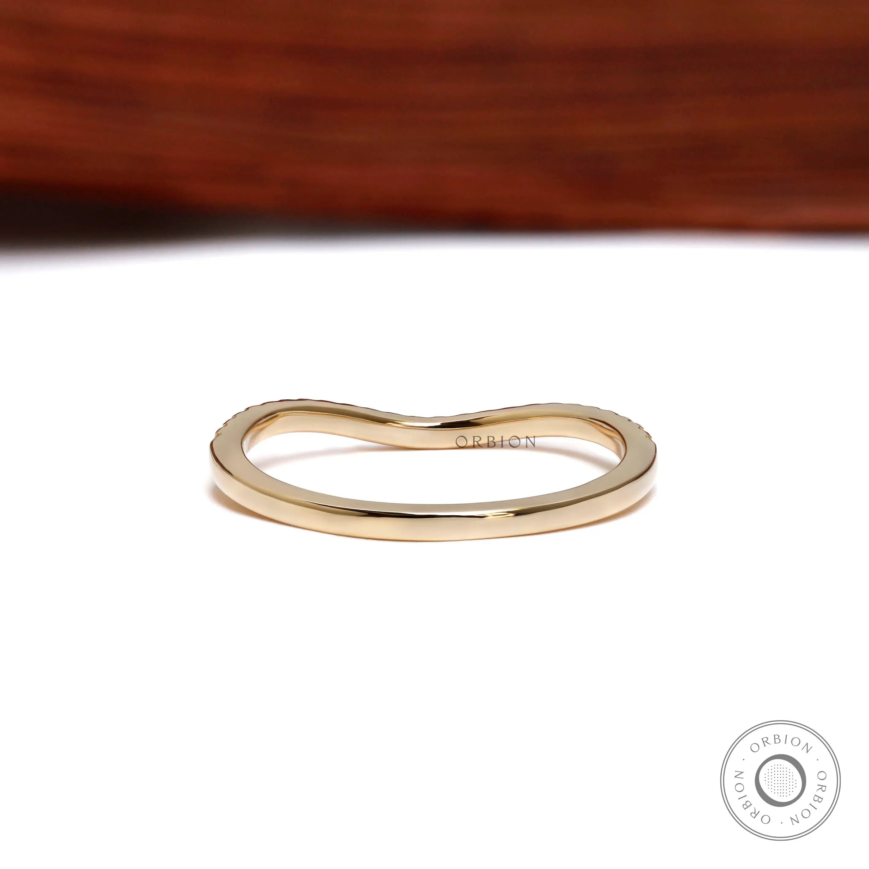 Back view of unique curved wedding band in yellow gold