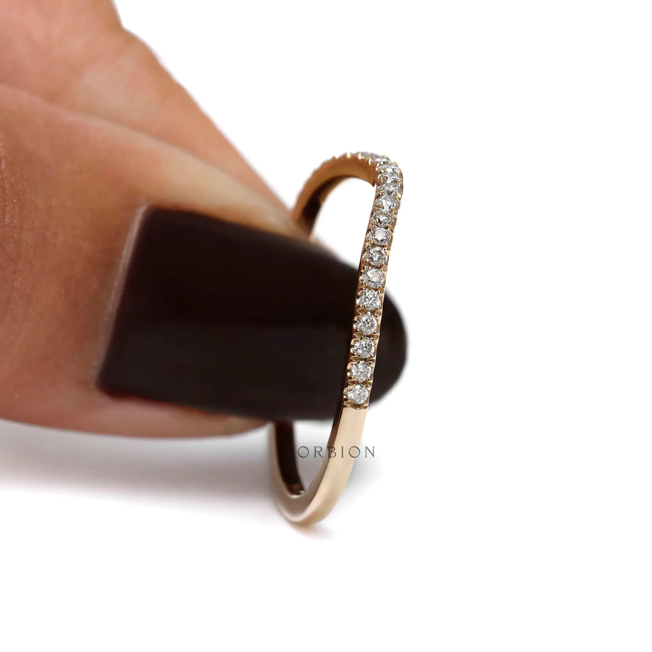 Side profile view of curved half eternity moissanite band