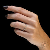 Hand model side view of curved moissanite wedding band