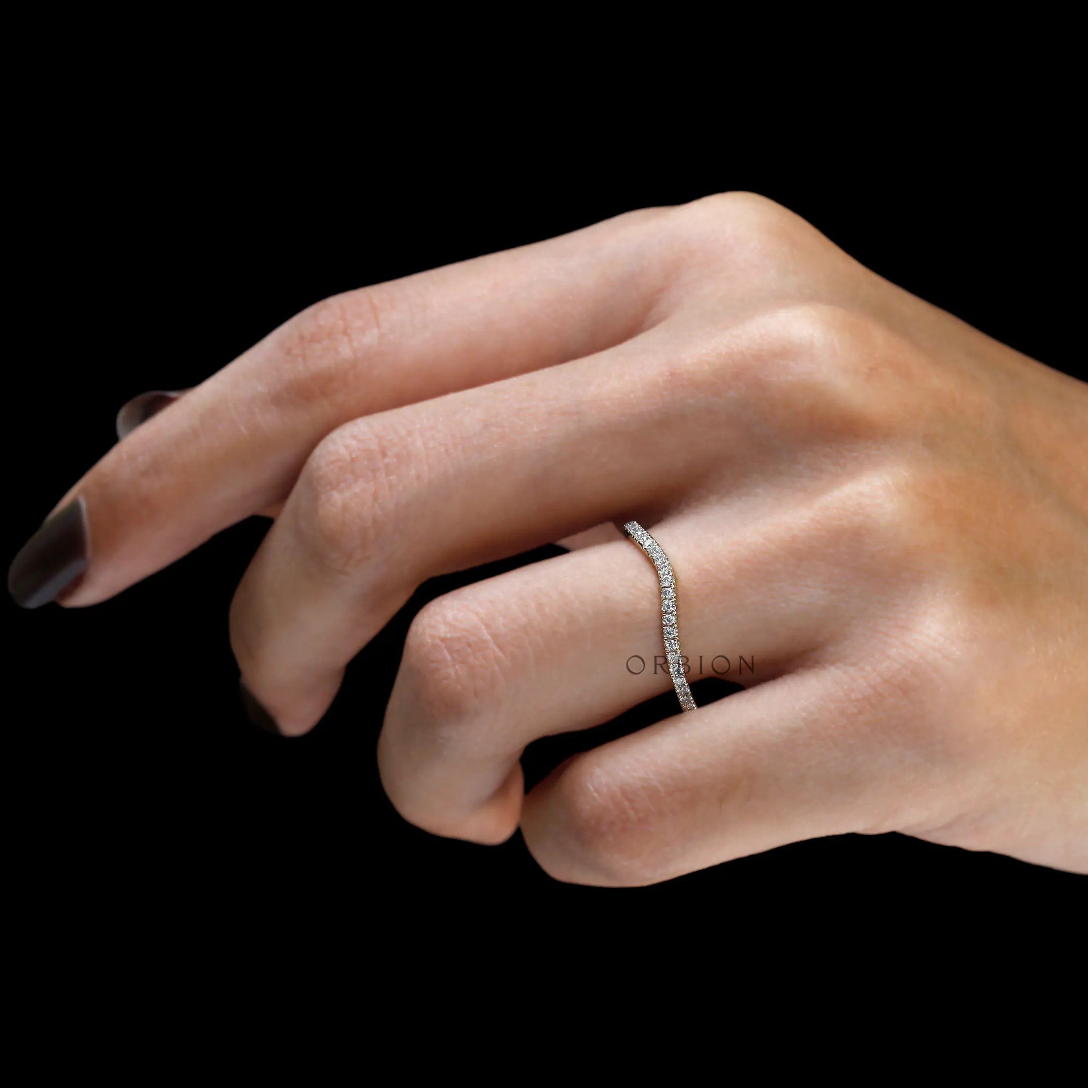 Hand model angled view of unique moissanite curved band