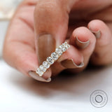 Side profile of oval moissanite half eternity band in polished gold