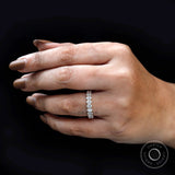 Oval moissanite half eternity ring held by hand with prong detail