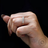 Oval moissanite half eternity band worn on finger close-up