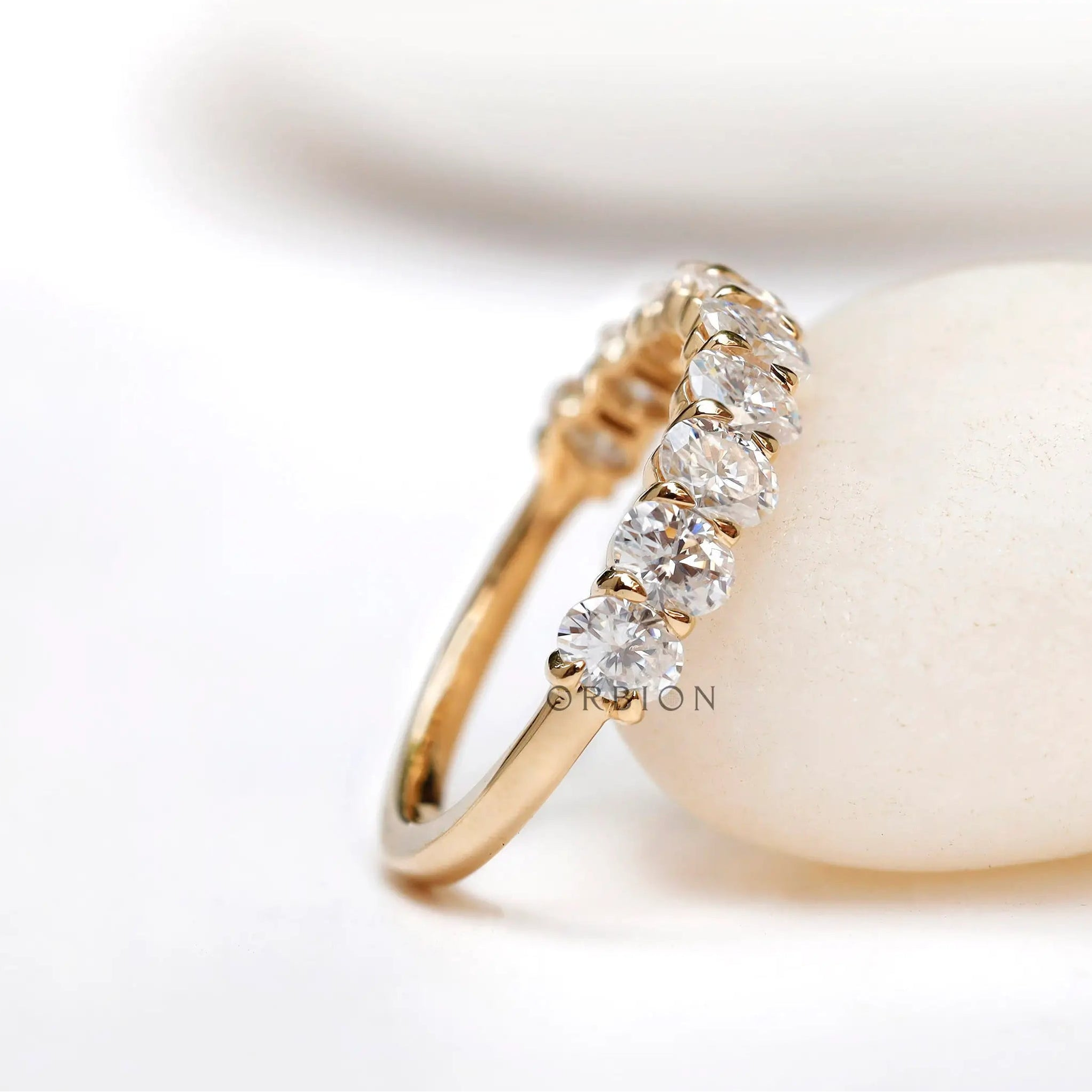 Angled view of oval moissanite wedding band with shared prong setting