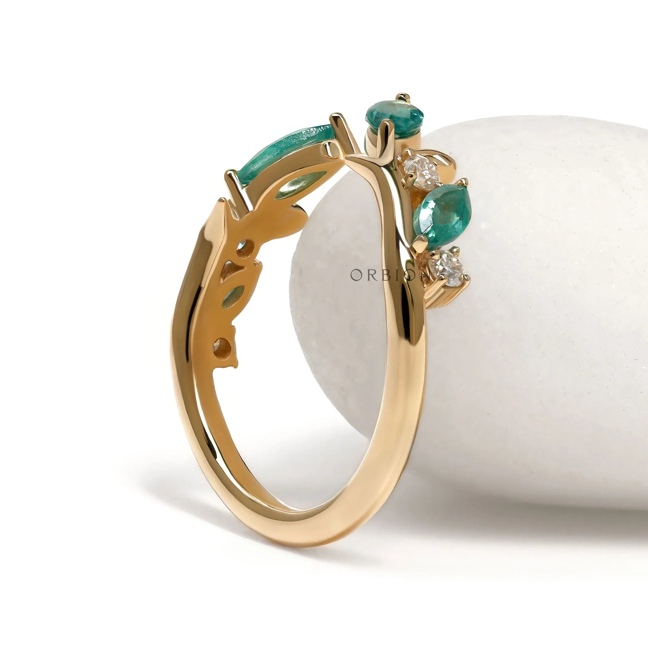 Yellow gold nature-inspired cuff ring with leaf and vine details and green lab gemstones
