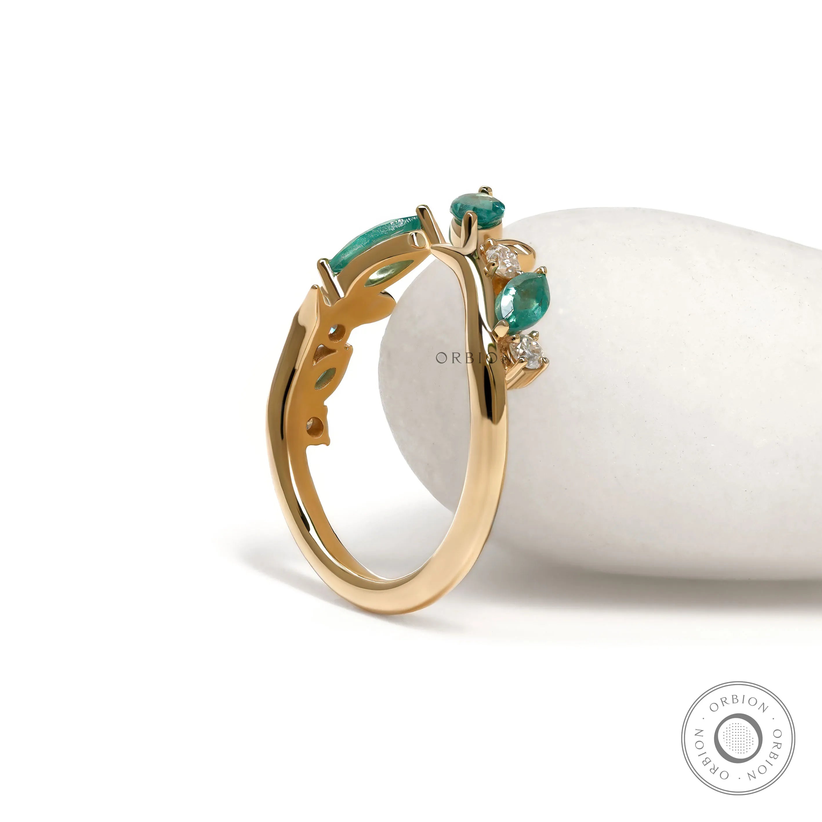 Yellow gold nature-inspired cuff ring with leaf and vine details and green lab gemstones