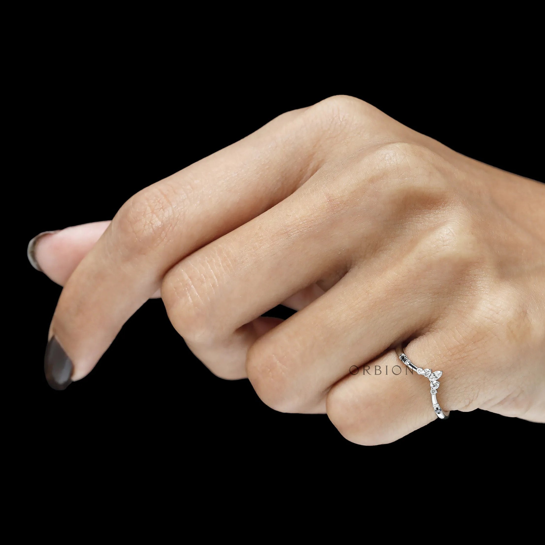 Curved wishbone wedding ring in platinum with black and white gemstones, minimalist fine jewelry design