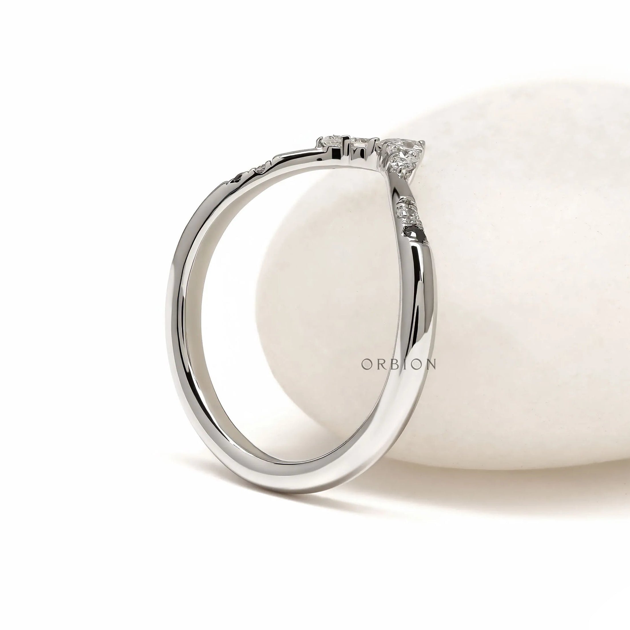 Minimalist platinum wishbone stacking ring with curved V shape and unique gemstone accents