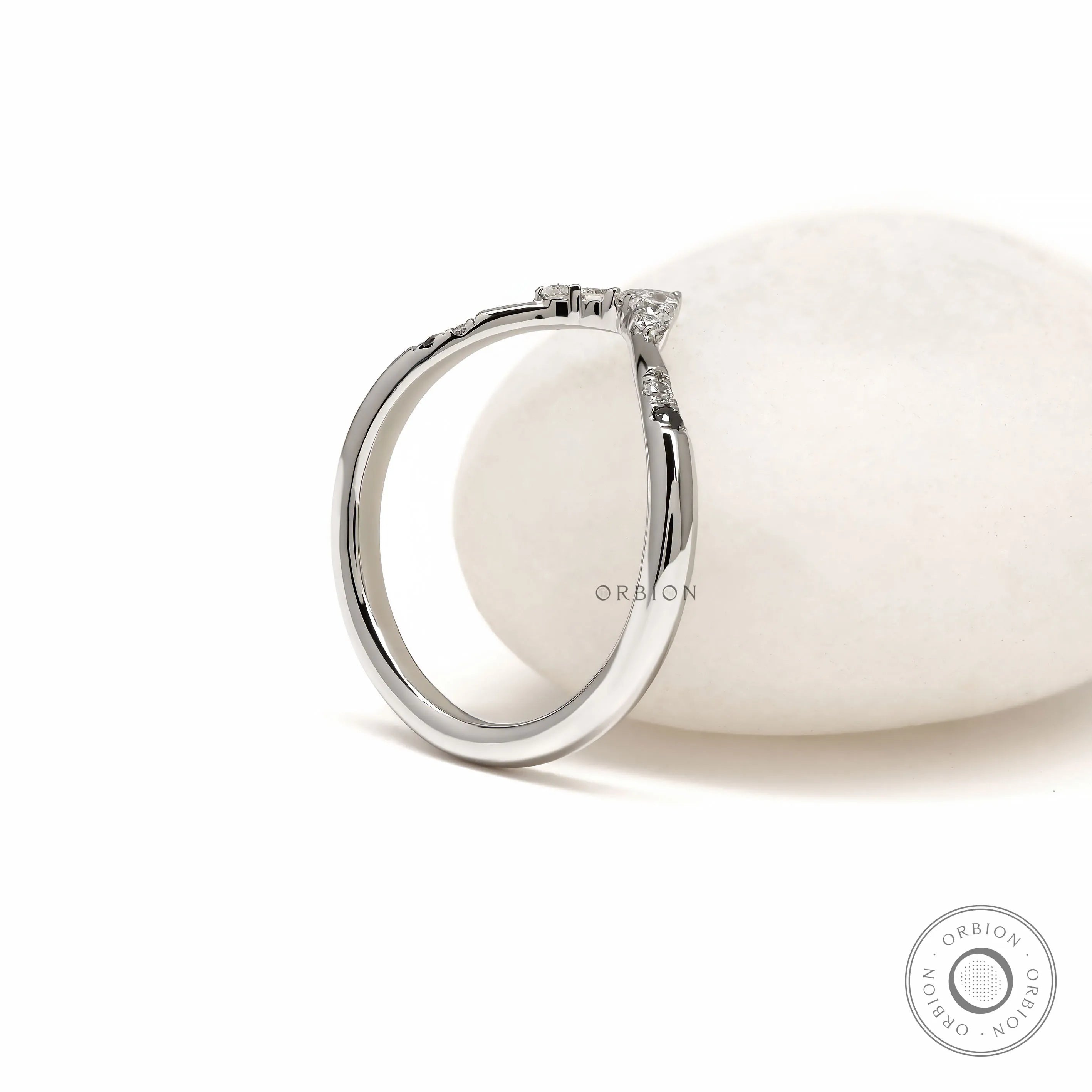 Minimalist platinum wishbone stacking ring with curved V shape and unique gemstone accents