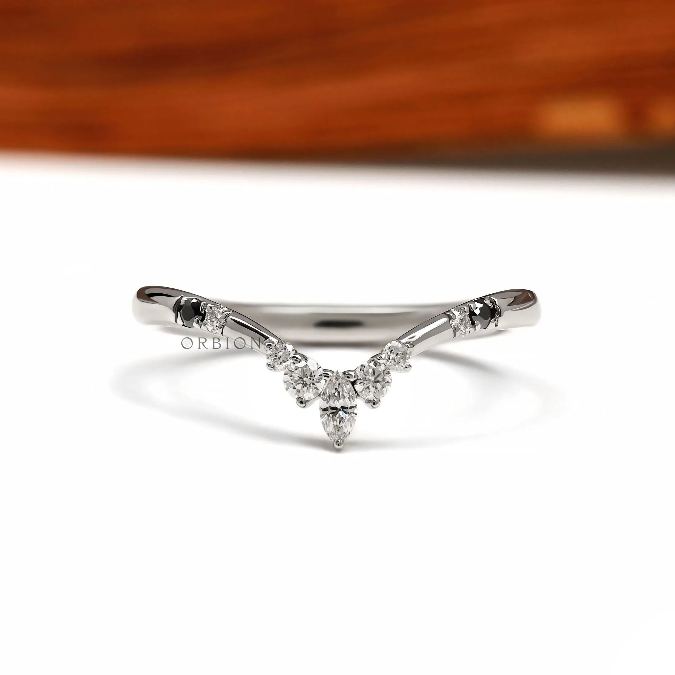 Platinum chevron wedding band with V shaped wishbone design featuring black and white gemstones