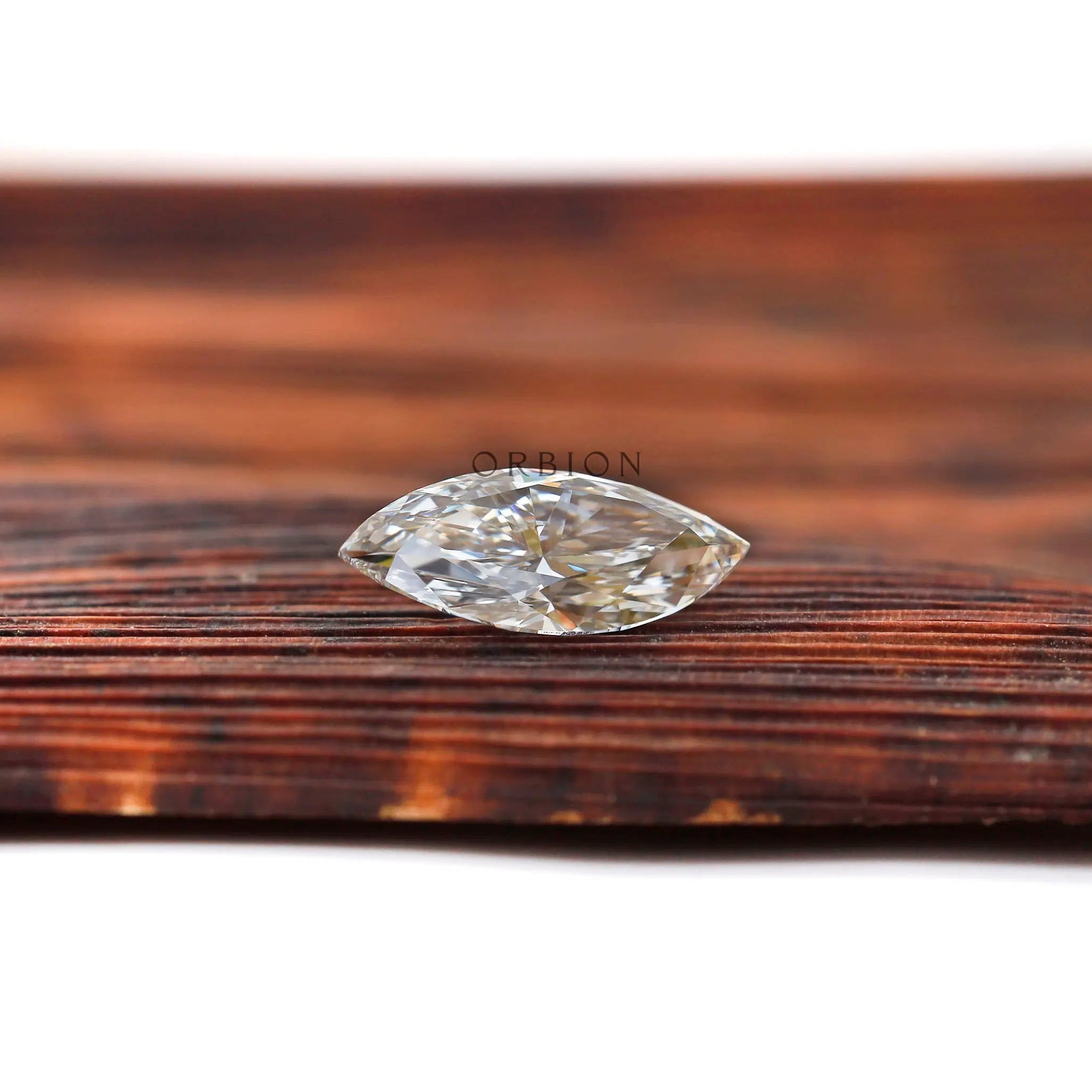 Off white marquise lab grown diamond on wooden surface