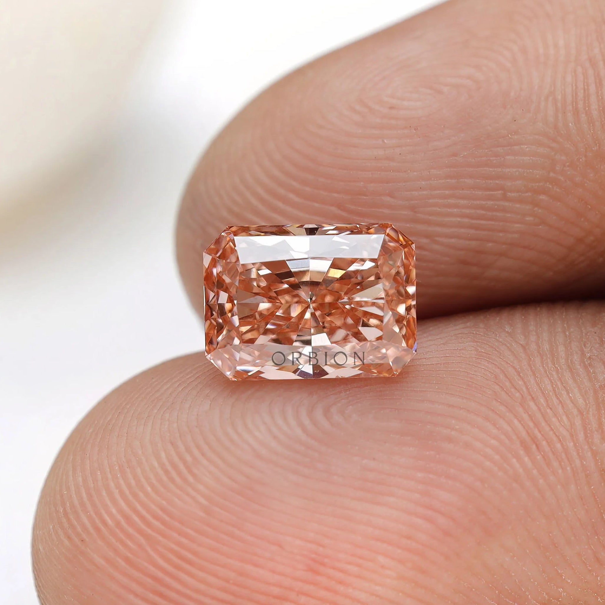 Radiant cut light pink lab grown diamond loose gemstone in hand
