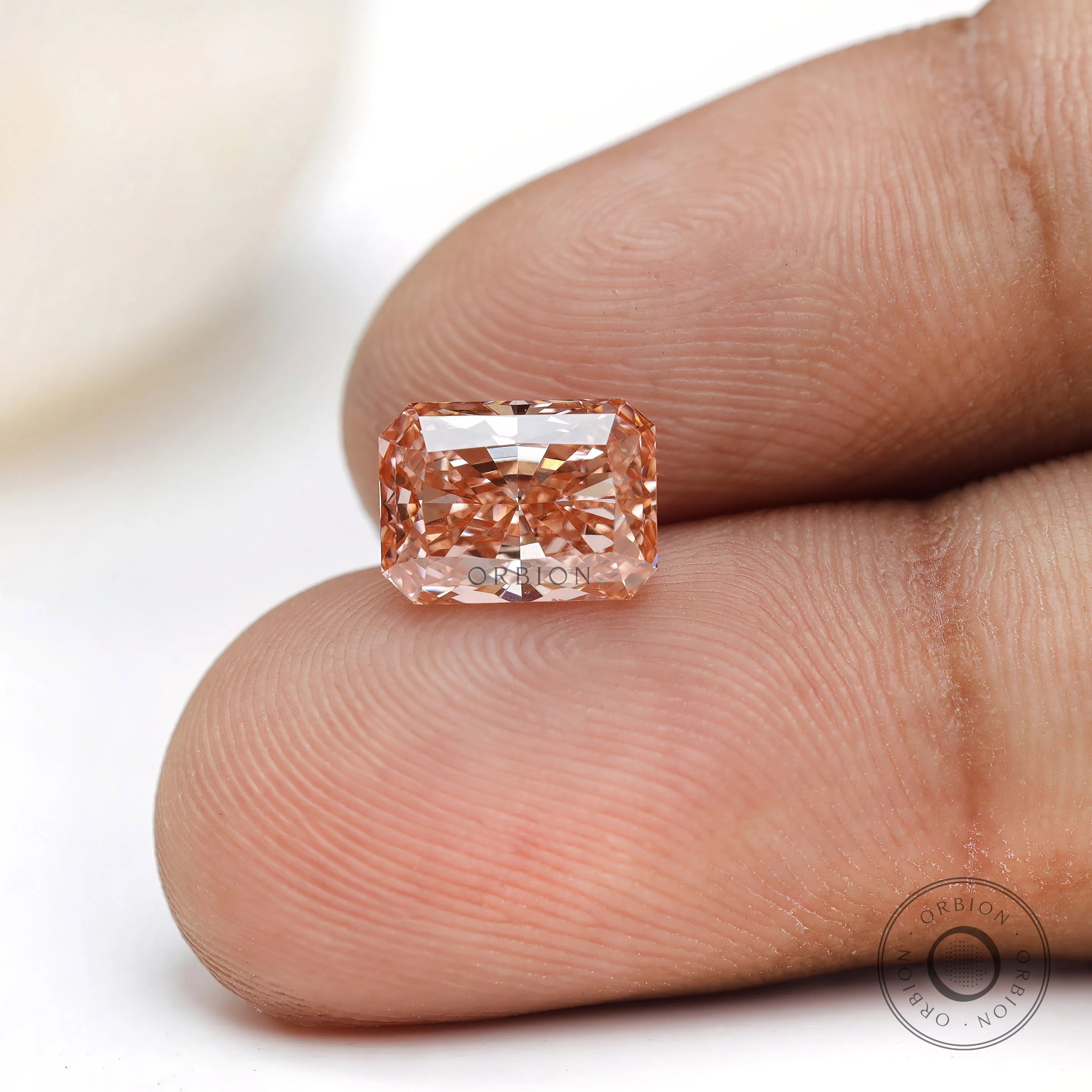 Radiant cut light pink lab grown diamond loose gemstone in hand