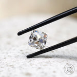 Cushion Peruzzi cut moissanite held in tweezers
