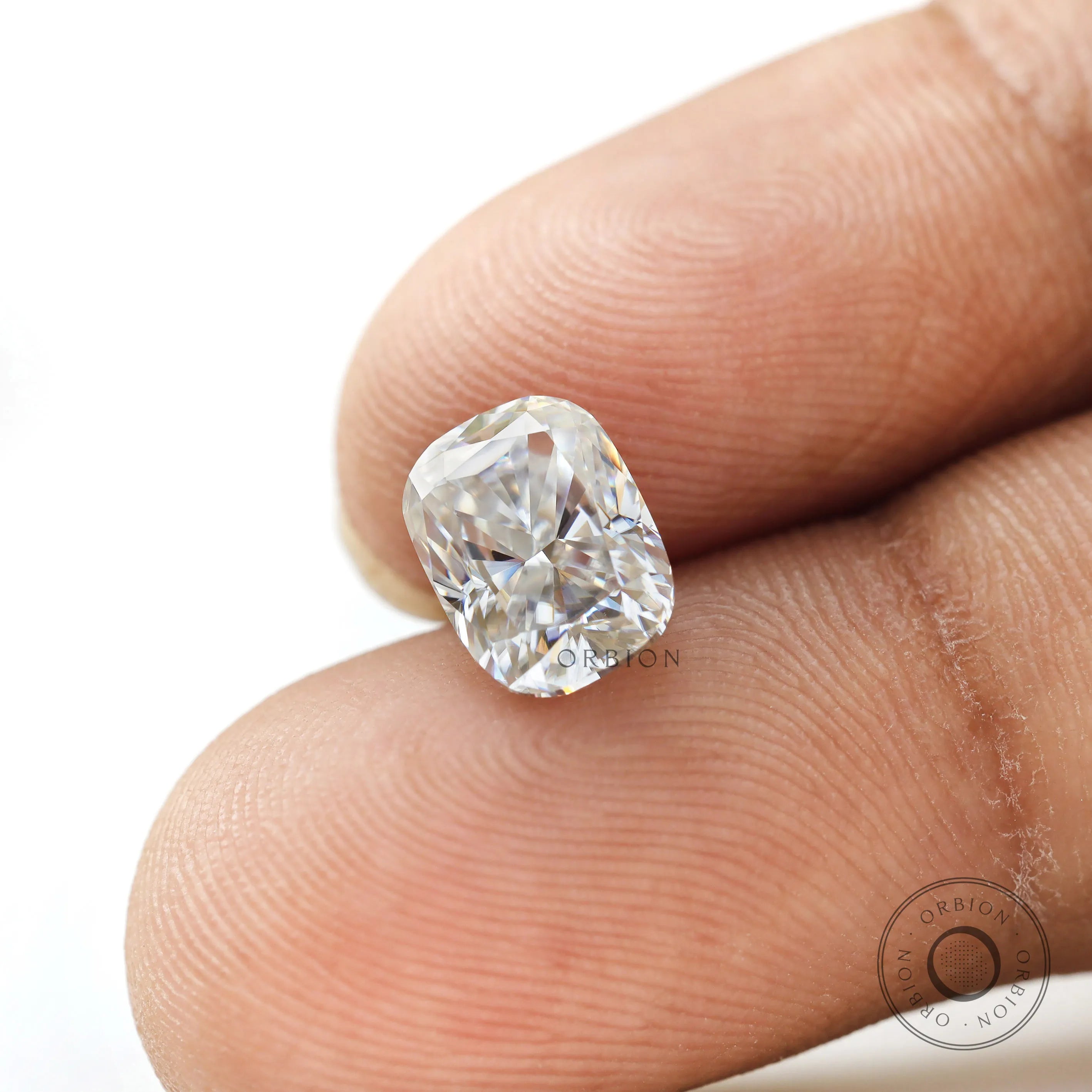 elongated cushion moissanite held on fingertip close view
