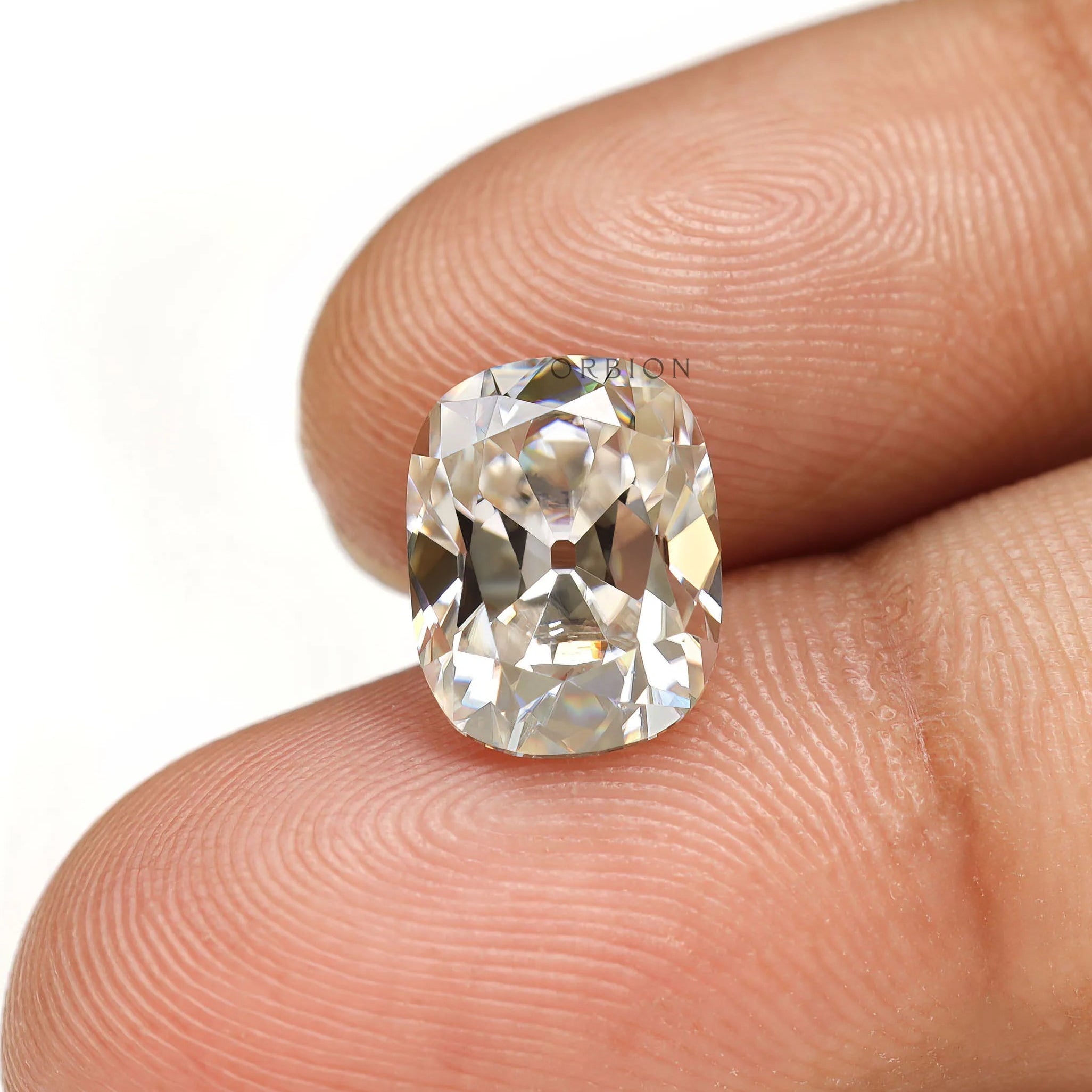 Elongated cushion moissanite off white color with antique cut detail