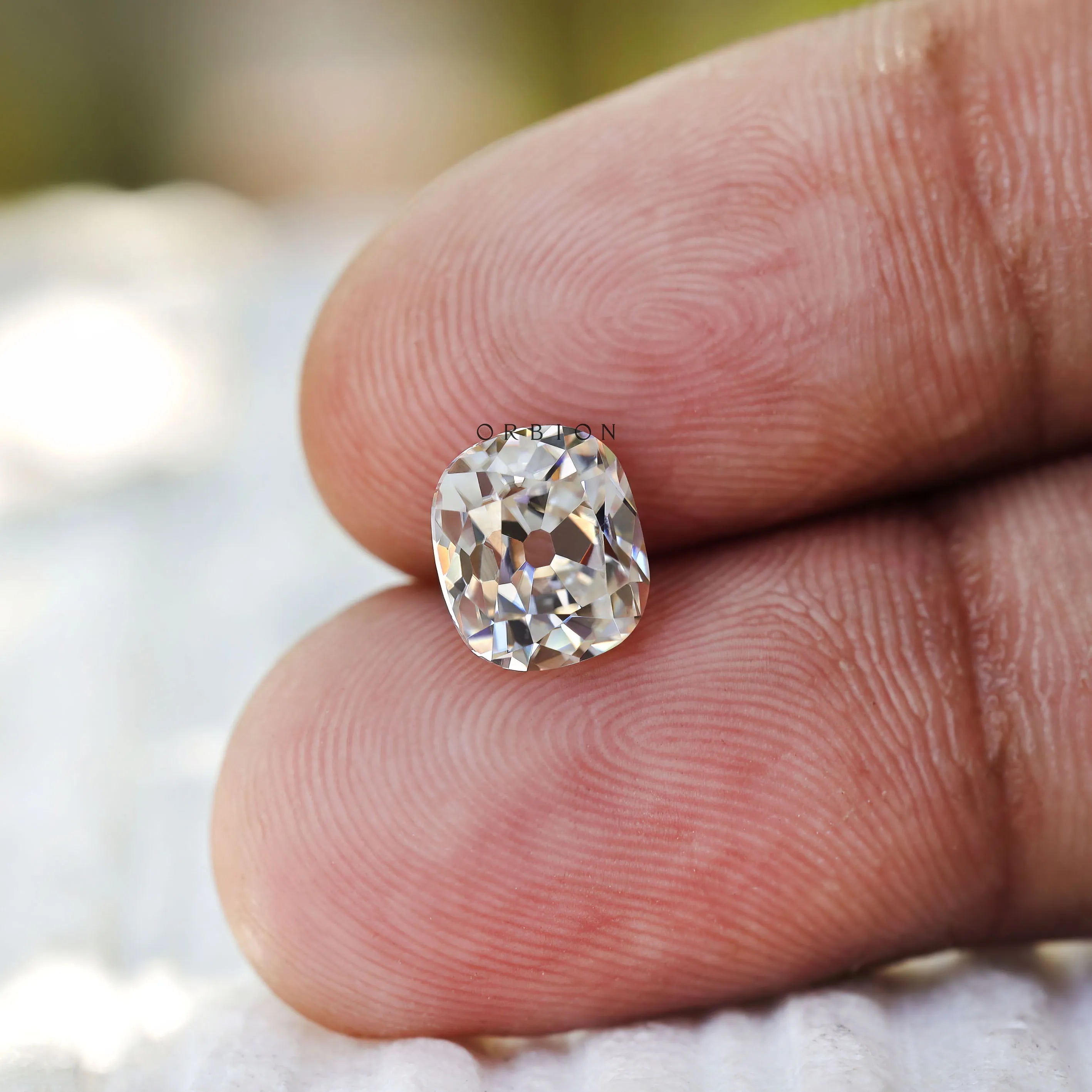 1.20 ct Elongated cushion moissanite with warm off white hue old mine cut