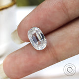 loose elongated cushion moissanite placed on fingertip close detail