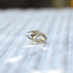 Side profile of yellowish moissanite showing depth and cut structure