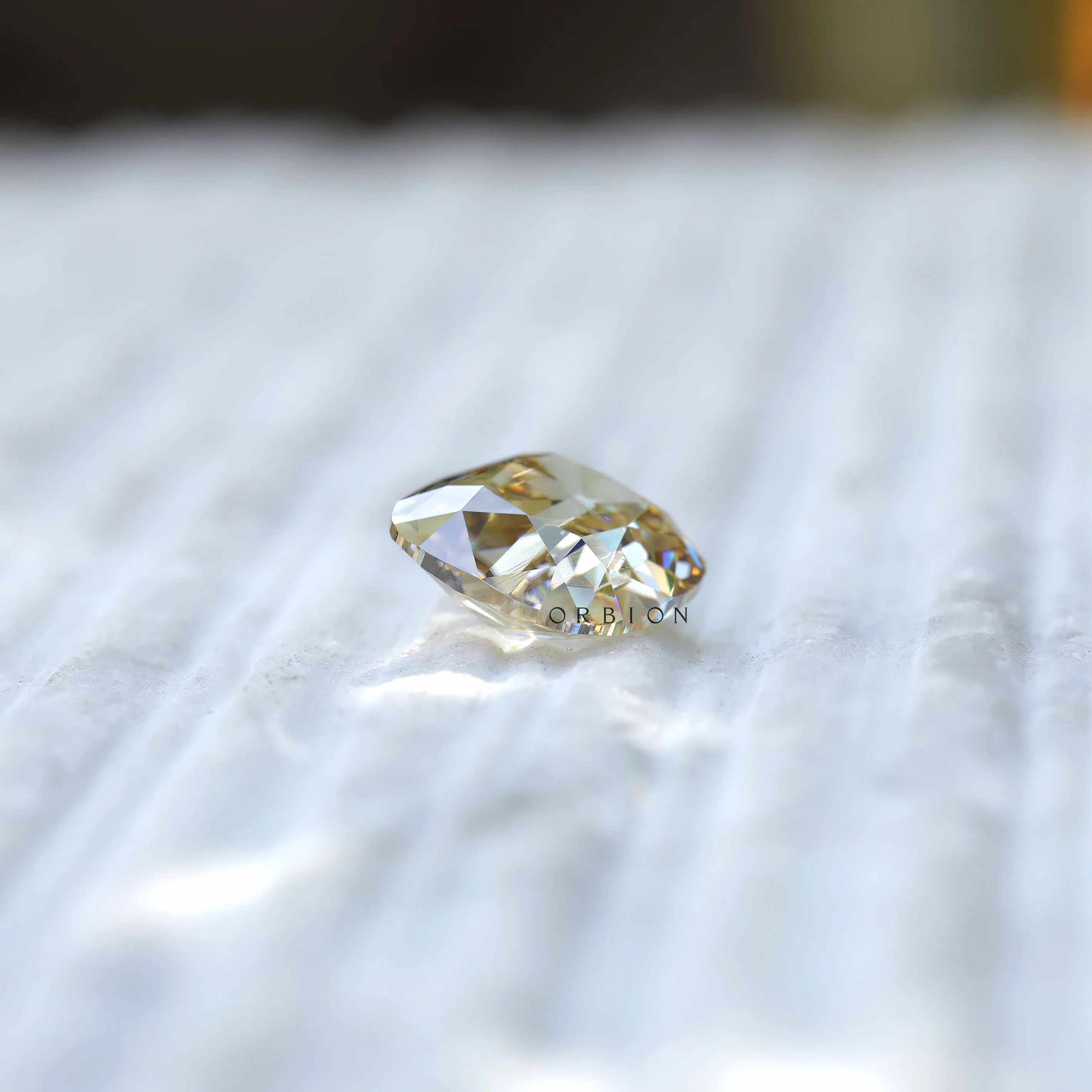 Side profile of yellowish moissanite showing depth and cut structure