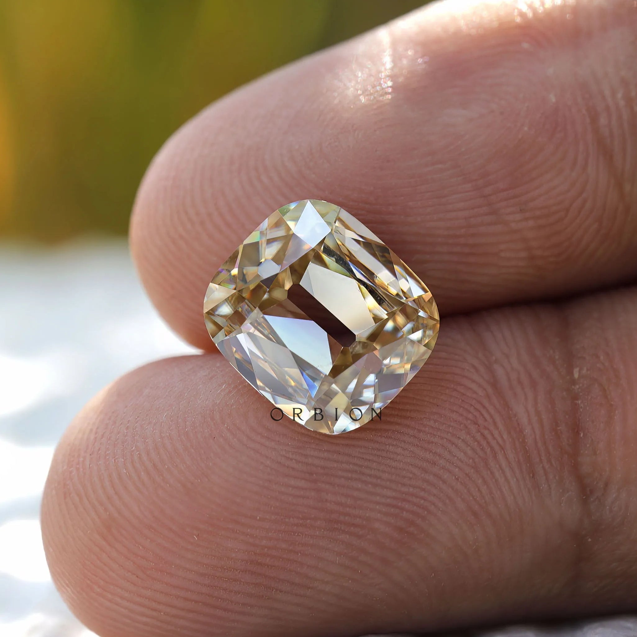 Top view of elongated cushion moissanite with soft yellow tone
