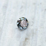 Side profile of grey round moissanite showing old European cut faceting