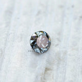 Side profile of grey round moissanite showing old European cut faceting