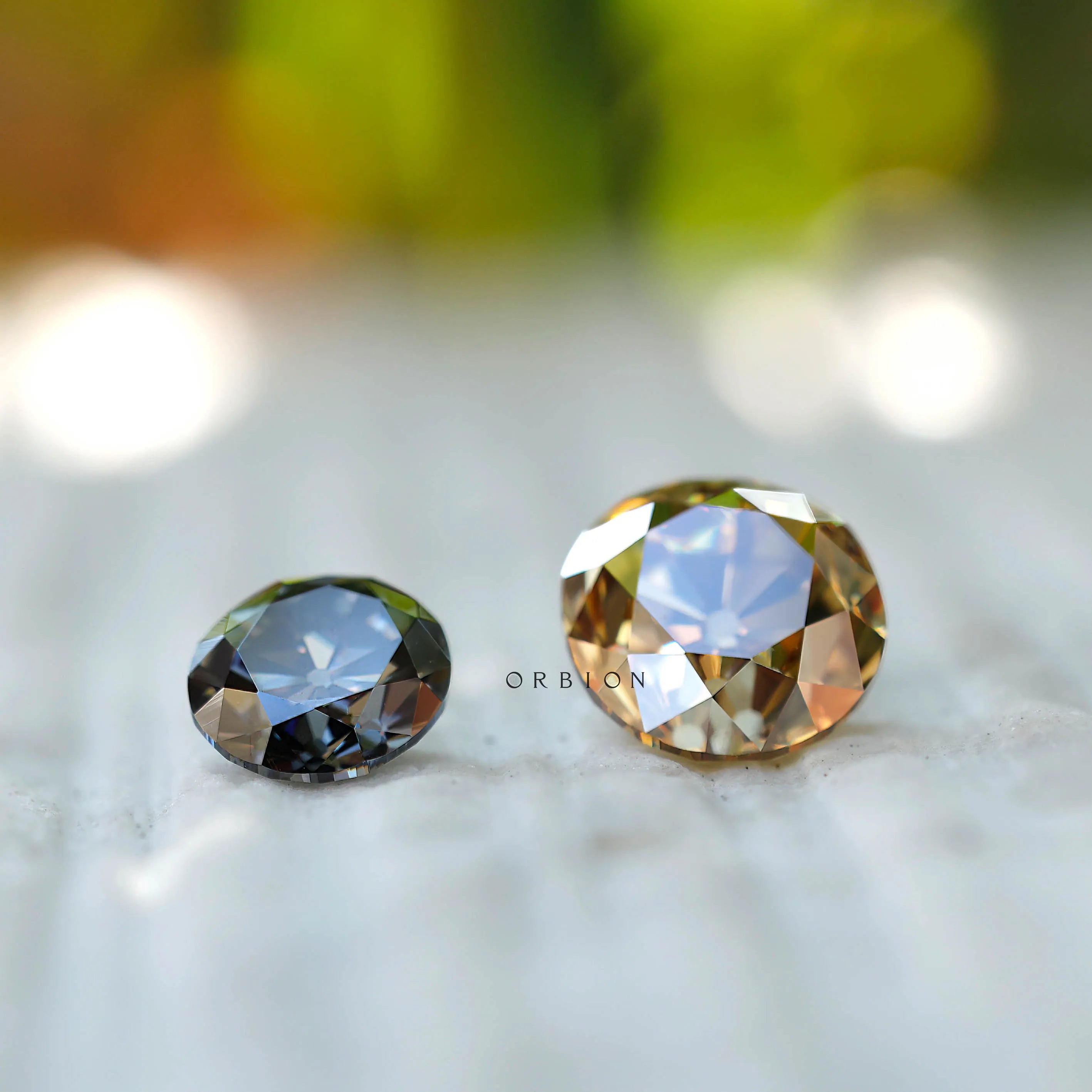 Comparison of grey and champagne moissanite stones showing color variation