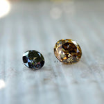 Comparison of grey and champagne moissanite stones showing color variation