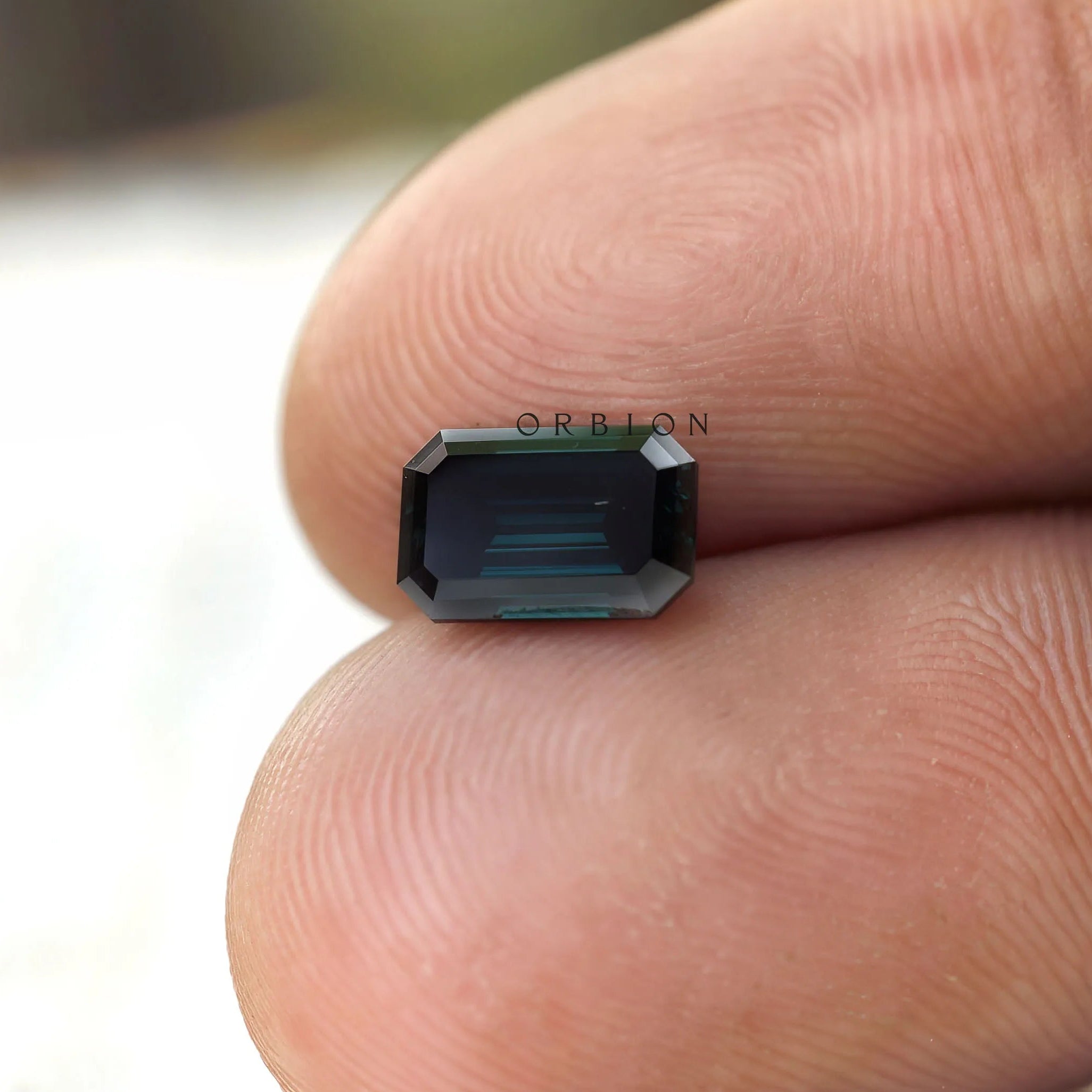 Emerald cut moissanite dark tone loose gemstone macro shot