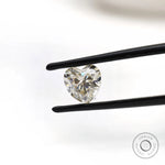 Heart cut moissanite displayed with tweezers minimal background