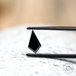 Kite shaped black moissanite with reflective surface close up